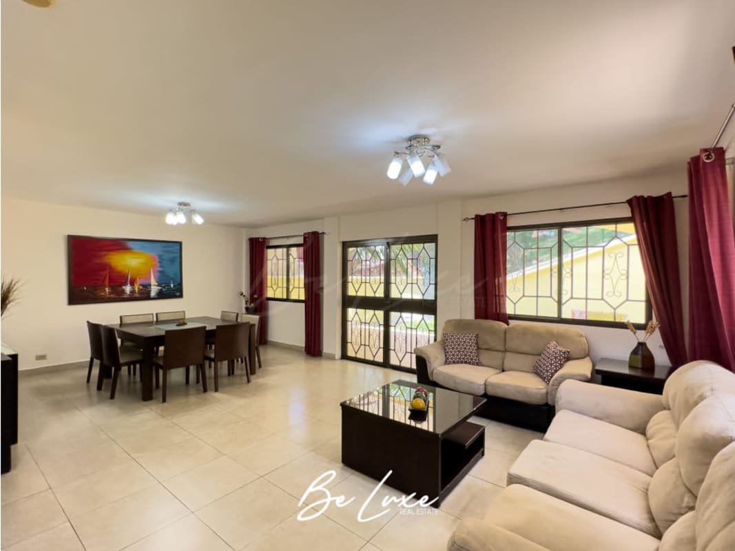 Living room with large windows, tiled floor, ceiling fan in house Ancón Panama for rent