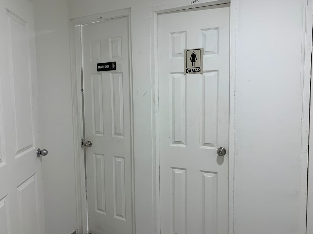 Interior hallway with restroom doors labeled at The Century Tower Panama City