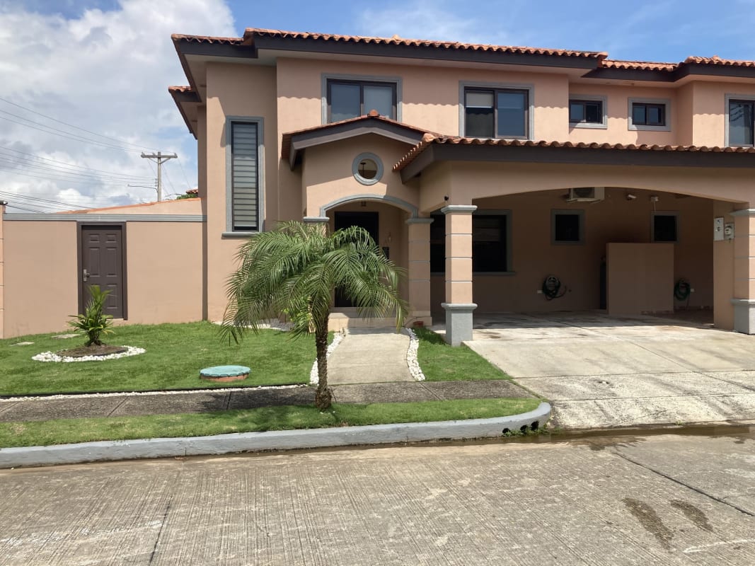 Two-story Mediterranean-style house with tile roof, palm trees, and driveway in Versalles Urbanization Panama