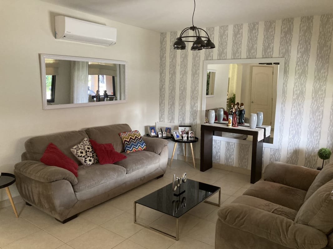 Enclosed backyard with grass, tropical plants, and privacy wall in Versalles Don Bosco Panama