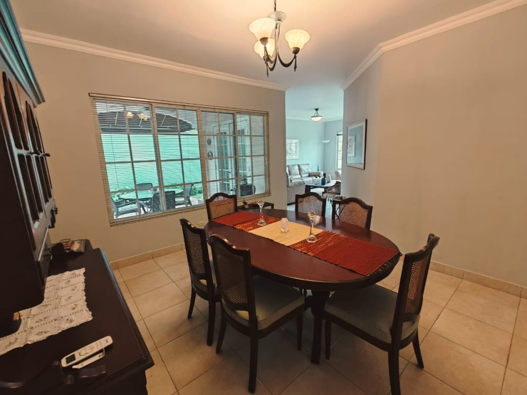 Spacious dining area with large windows open to living room in Costa Azul house Panama City