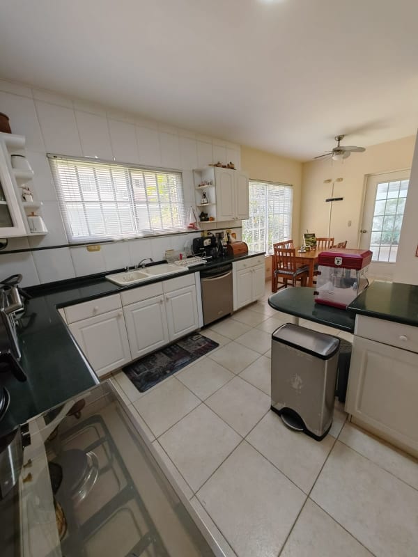 Traditional kitchen white cabinetry, black countertop, large windows in Costa Azul Costa del Este