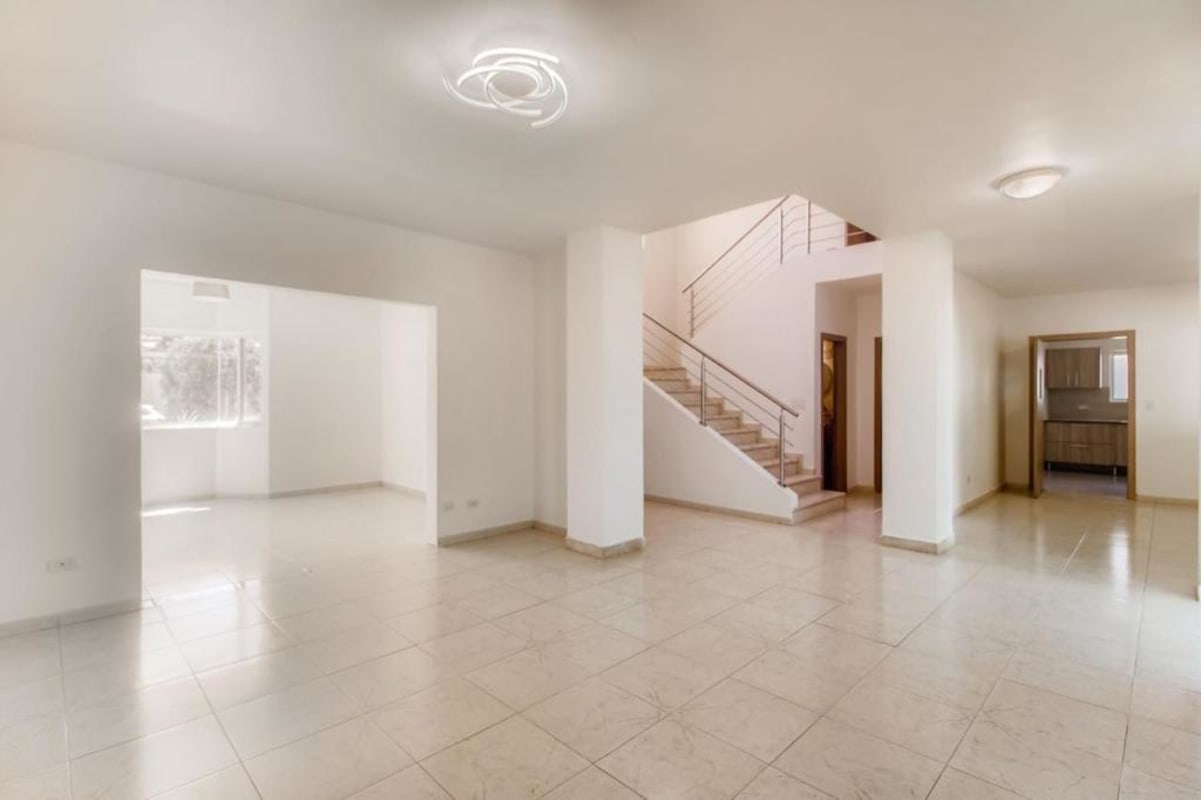 Spacious living dining area with large windows, tiled floor, neutral colors in luxury home Costa del Este Panama