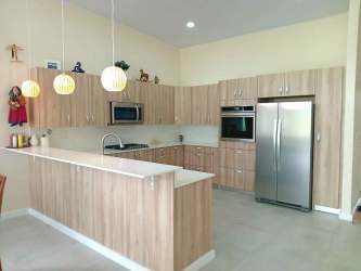 Chef’s kitchen with granite countertops, wood cabinetry and appliances included in Boquete house Panama