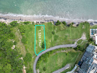 Aerial of oceanfront lot outlined near paved road in beachfront Punta Caelo Panama
