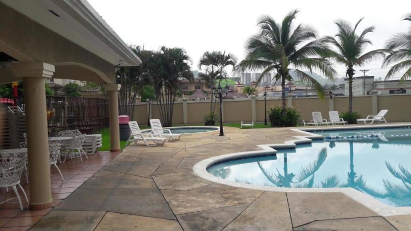 Swimming pool with jacuzzi, palm trees, and lounge chairs in Dorado Lakes Condado del Rey