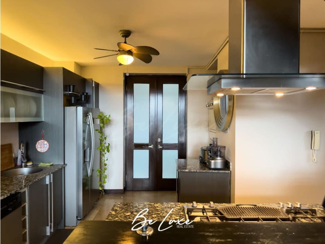 Open kitchen with wine rack, granite counters, ceiling fan in Casco Viejo loft Panama City