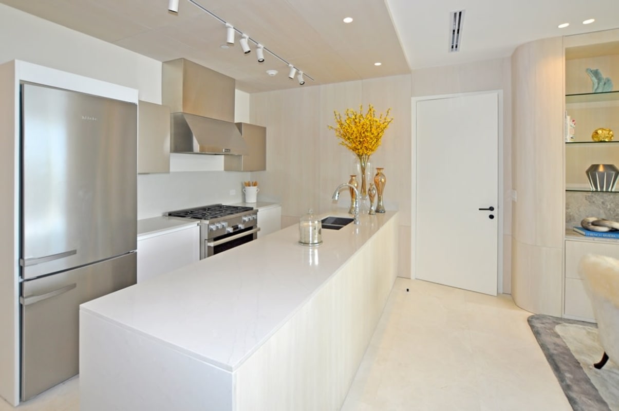 Contemporary kitchen with marble island adjoining stylish living room in Punta Pacifica condo