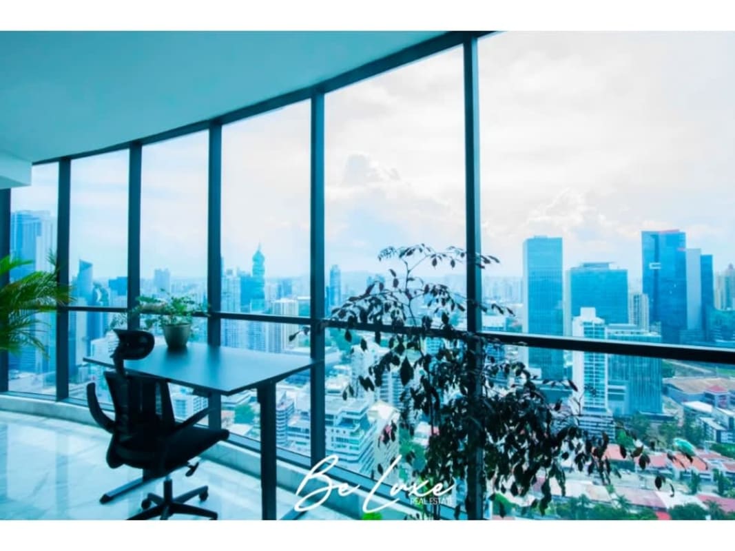 Spacious office with floor-to-ceiling windows showing Panama skyline in luxury penthouse PH Ocean Front