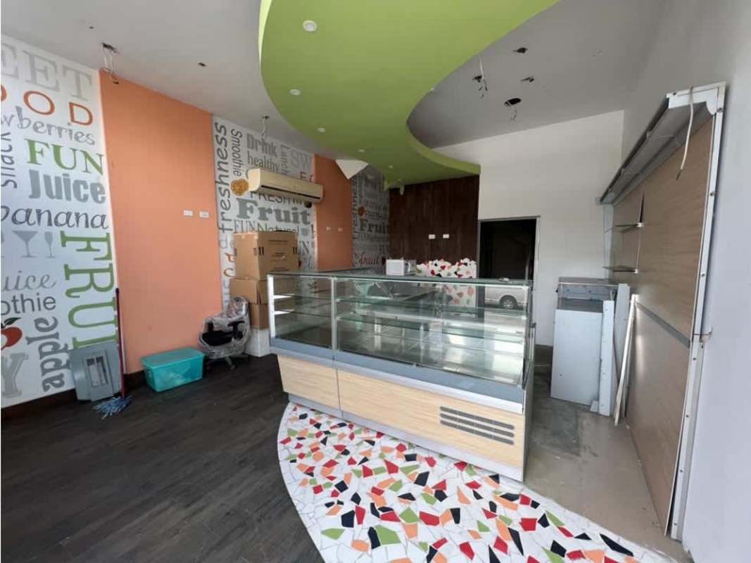 Bright juice bar interior with typography wall art, colorful floor tiles, curved ceiling accent for commercial lease Panama City