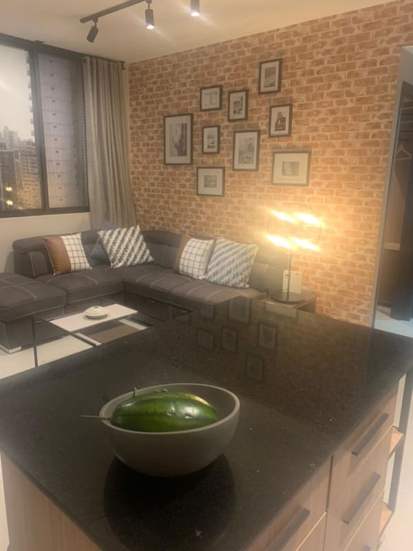 Modern kitchen with breakfast island, black countertops, wood cabinetry in PH Nostrum Obarrio Panama