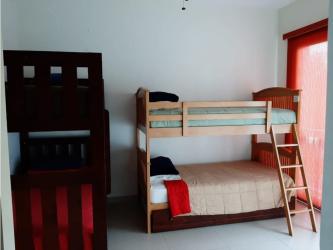 Furnished bedroom with terrace access overlooking ocean and resort pool in Bijao Panama