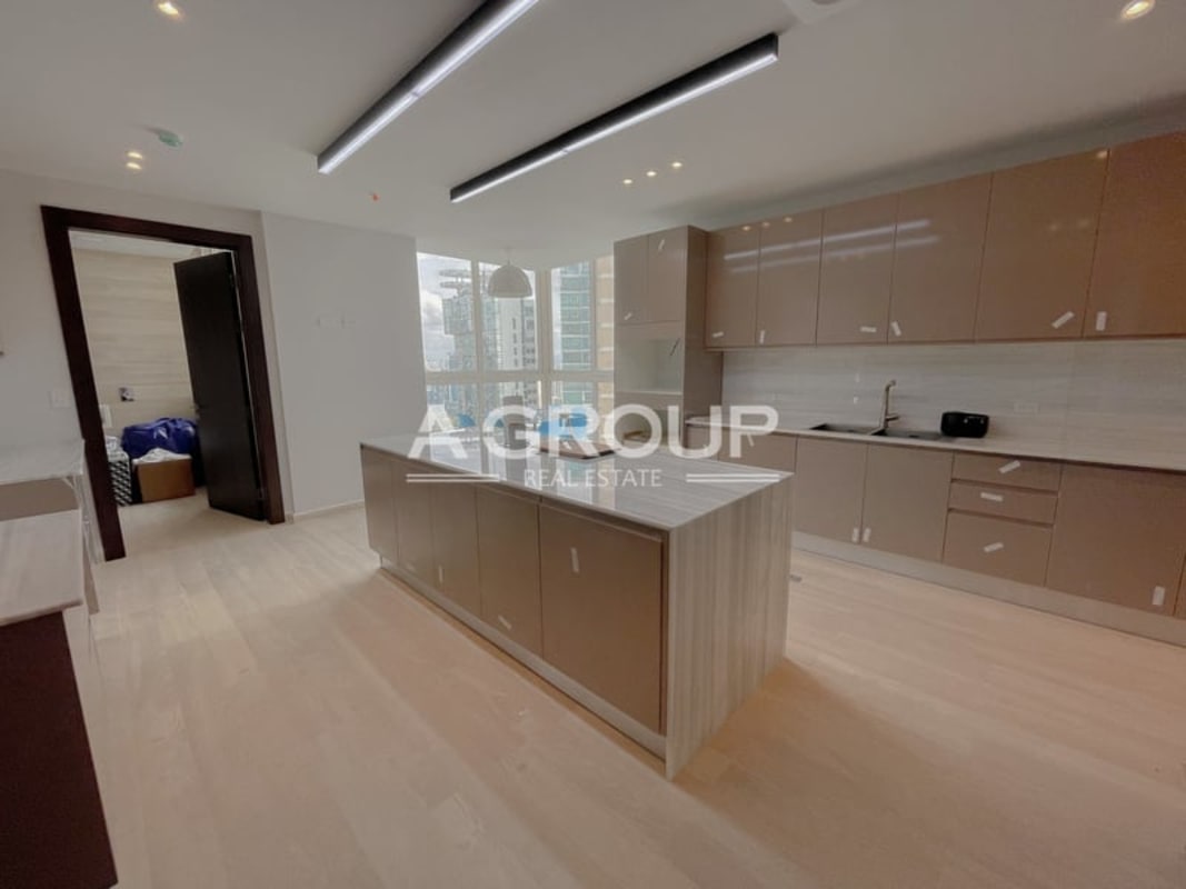 Contemporary kitchen with island quartz waterfall countertop and city views at The Towers Punta Paitilla Panama