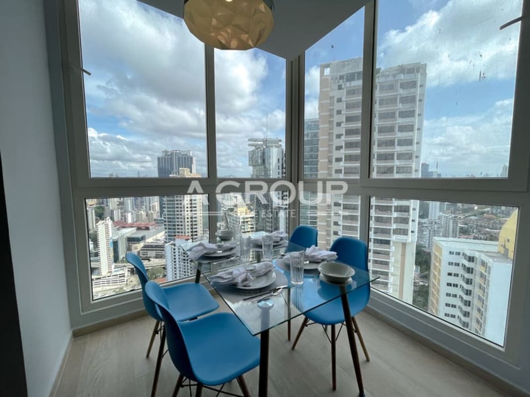 Dining area with blue chairs and glass table enjoying panoramic city skyline views in The Towers Punta Paitilla