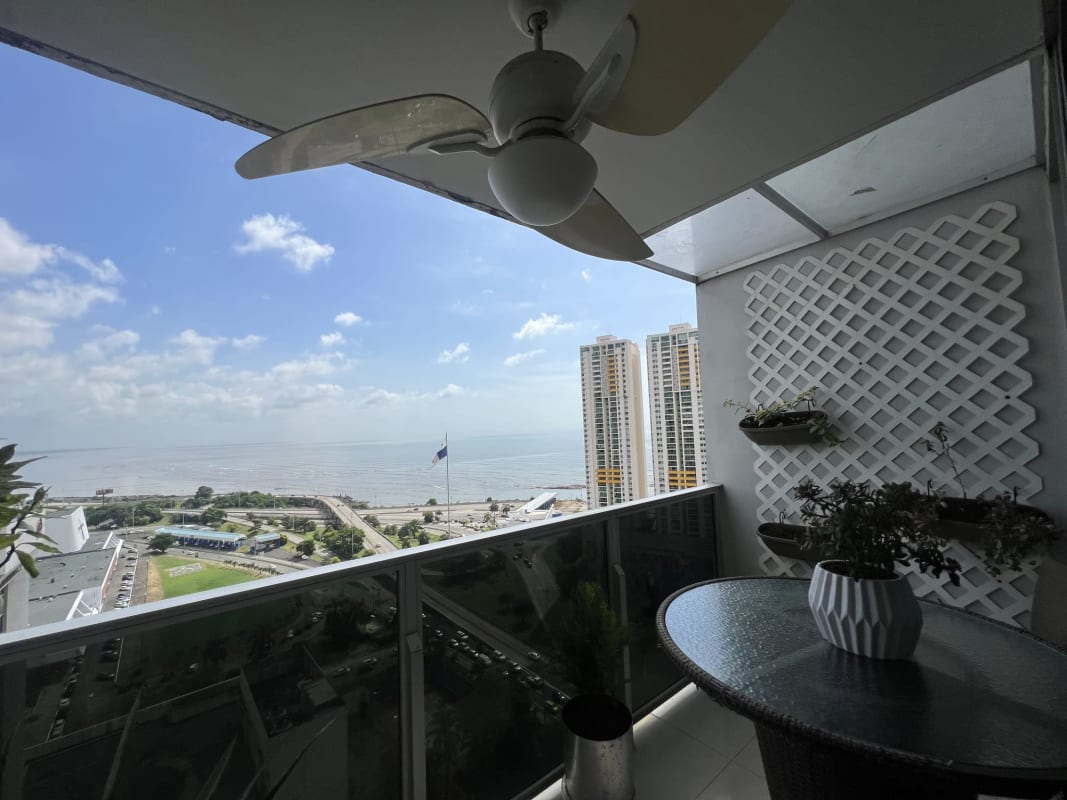 Modern balcony with potted plants, glass rail, lattice wall panels, city skyline and ocean view at PH Prive San Francisco