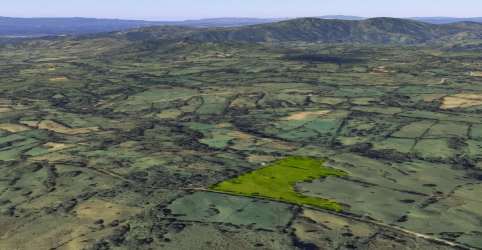 Aerial showing farmland plot with adjacent fields and mountainous background in Chiriqui, Panama