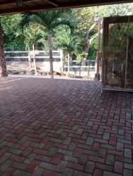 Gated entrance to estate with brick driveway and tropical landscaping in Chame Panama