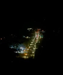 Night aerial of city lights and traffic roadways near land for sale Volcán