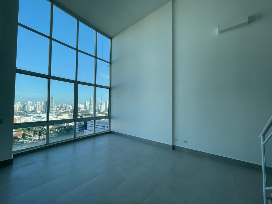 Modern living room with floor-to-ceiling windows overlooking city at PH Costa Pacifica