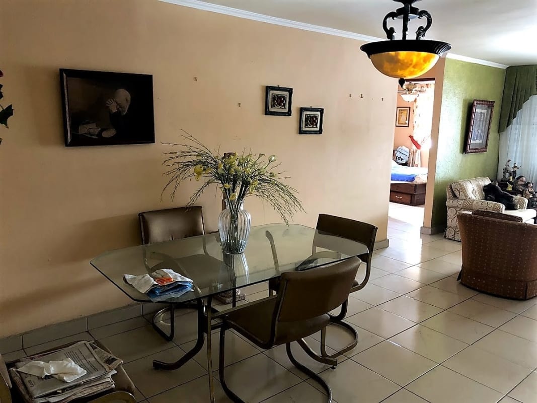 Traditional dining area with glass table brown chairs tile floor in Los Ángeles Panama