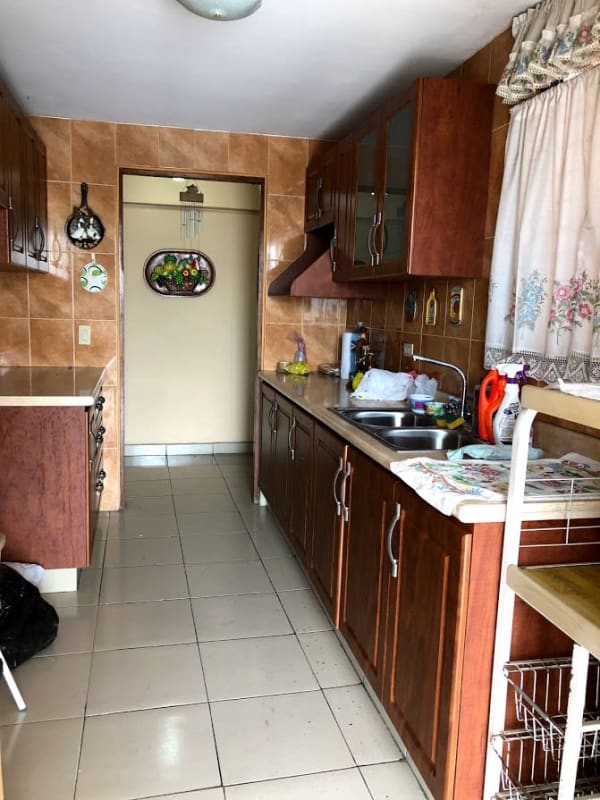 Kitchen with wooden cabinets tiled walls double sink in Los Ángeles Panama