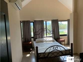 Bedroom with metal bed frame, AC, large window and vaulted ceiling in Brisas de Coronado townhouse