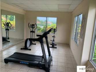 Open plan dining and kitchen area with black staircase in Brisas de Coronado townhouse Panama