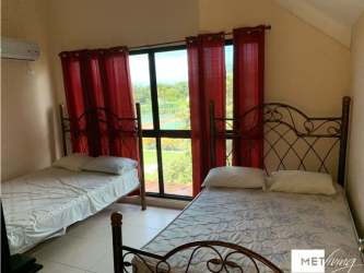 Double bed bedroom with large window, AC, red curtains at Brisas de Coronado Panama