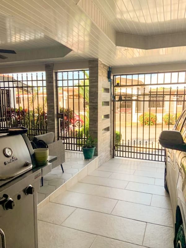 Covered carport with tiled floors, grill station, metal gate and outdoor seating San Antonio Panama City