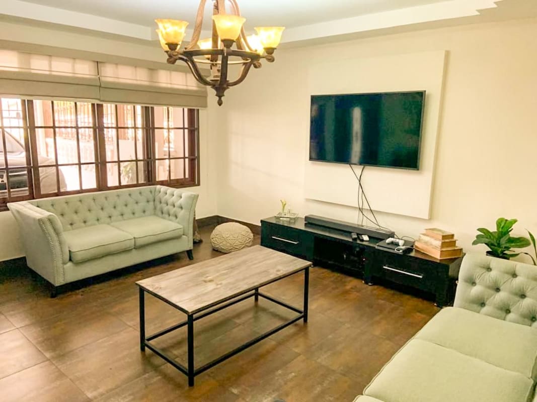Modern living room with tufted sofas, large window, entertainment console in San Antonio Panama
