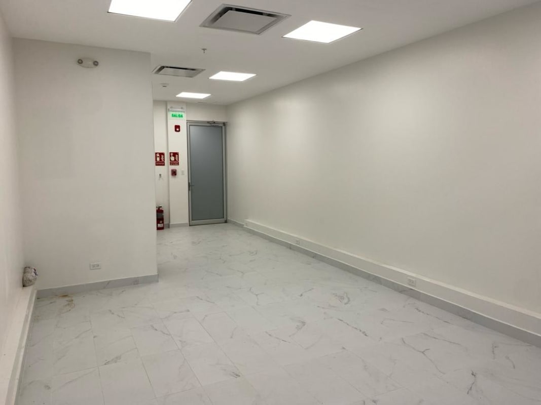 Empty office room with marble tile floor, recessed ceiling lights and large glass wall TownCenter Costa del Este Panama
