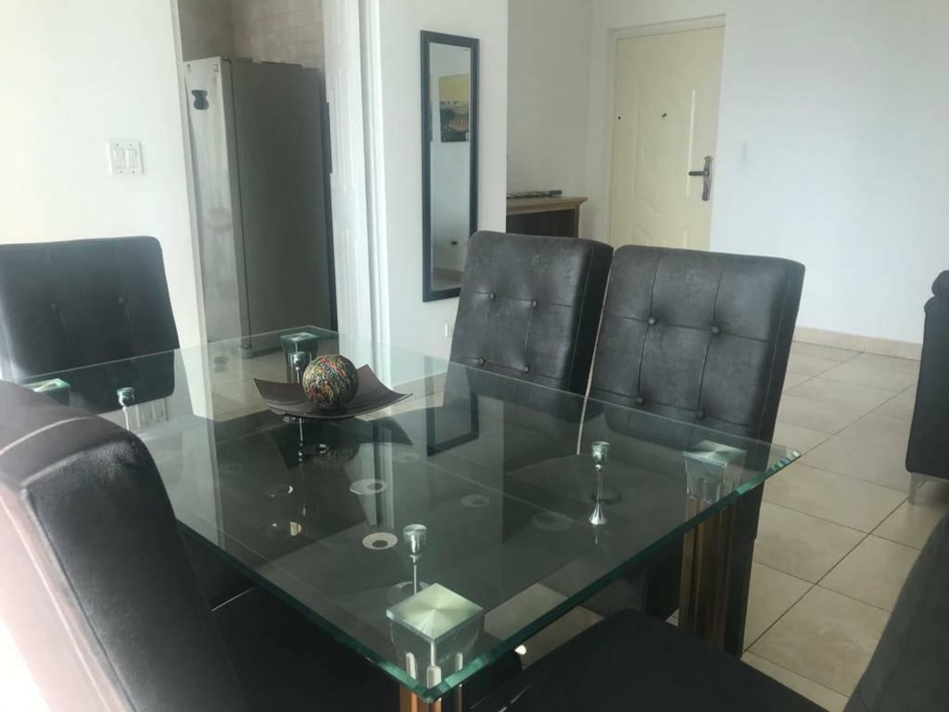 Bright dining area with glass table and cushioned chairs at PH ParkView San Francisco Panama City