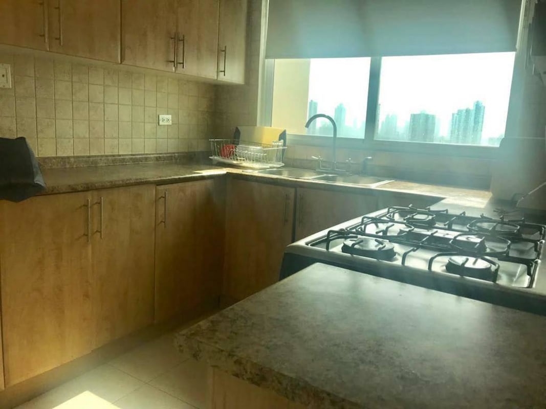 Kitchen with granite countertops, wood cabinetry and appliances in PH ParkView San Francisco Panama