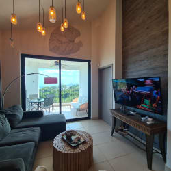 Spacious living room with large glass doors to balcony and ocean view in PH Ensenada, Panama
