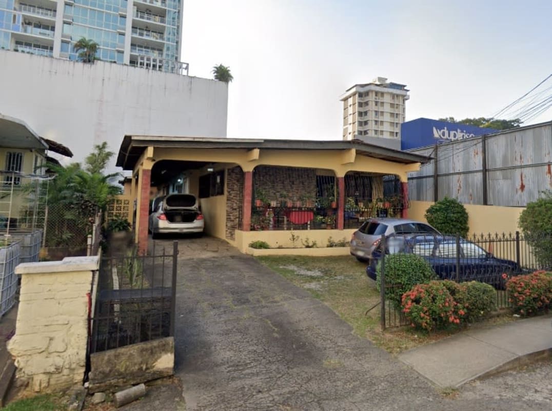Large Panama City house with iron fence, garden, front porch, and driveway near San Francisco center