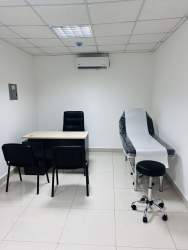 Clean examination room with exam table, desk, chairs inside Hospital Chiriquí Tower David Panama