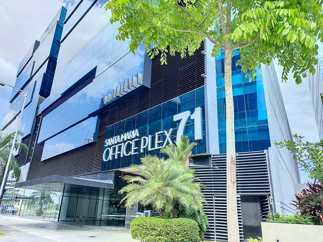 Modern glass facade of Santa Maria Office Plex 71 with reflective blue windows in Business Park Panama City