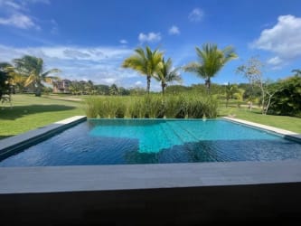 Private swimming pool surrounded by lush landscaping in Buenaventura Peninsula villa Panama