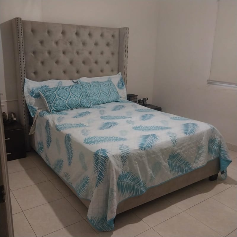 Modern bedroom with tufted grey headboard tile flooring Dorado Springs Panama