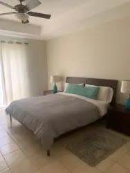 Bedroom with neutral tones, ceiling fan, large window Buenaventura luxury apartment