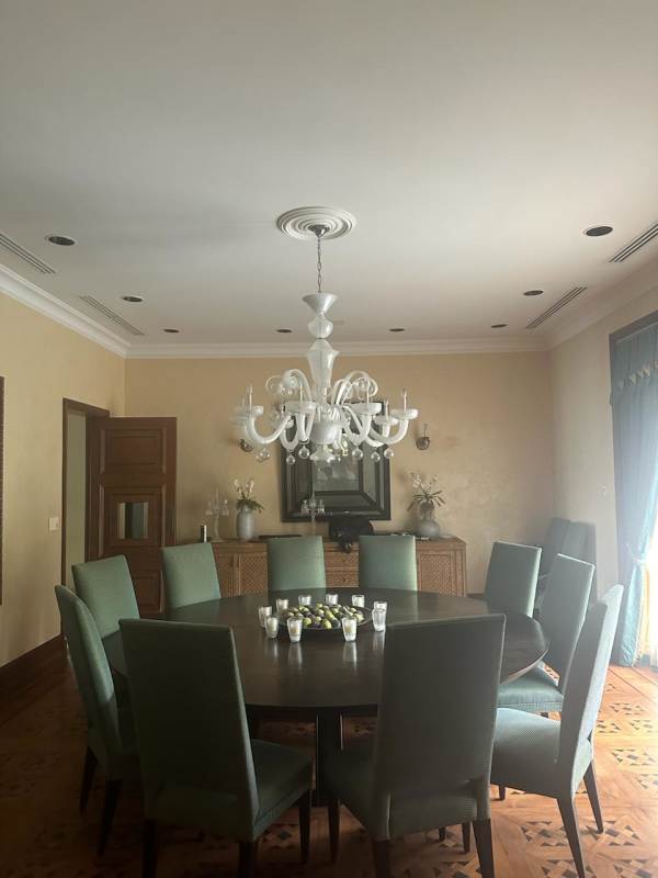 Round dining table with upholstered chairs and chandelier Panama mansion