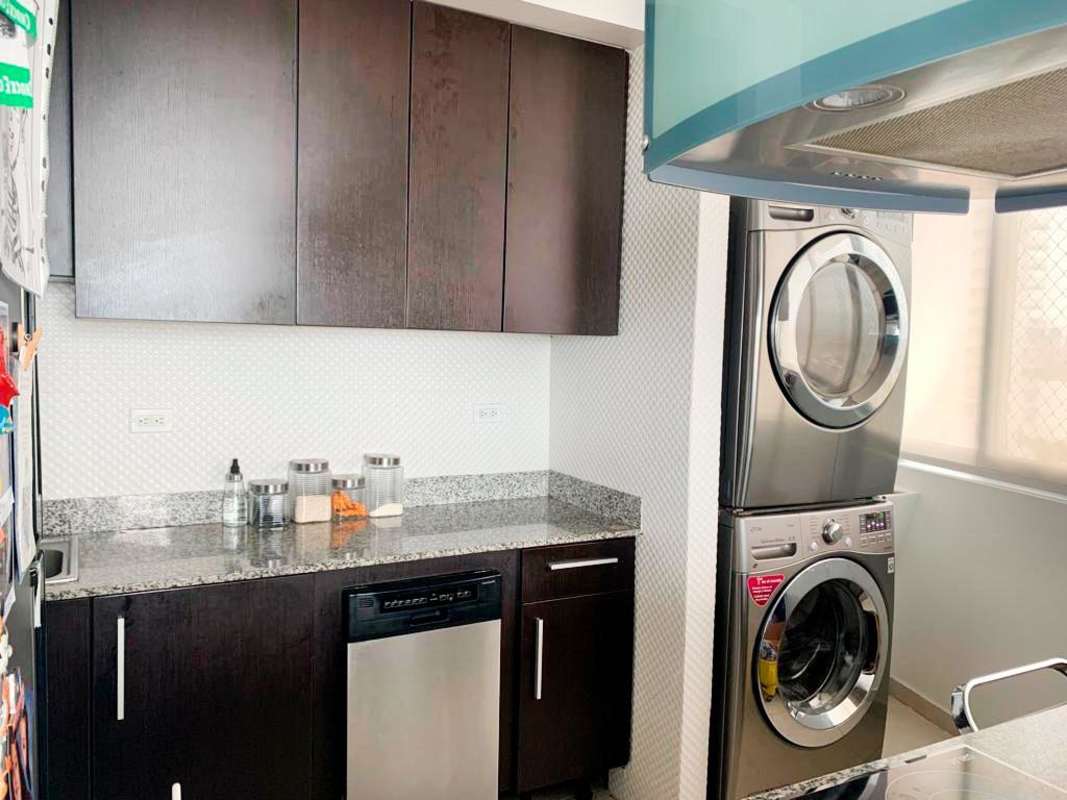 Upgraded kitchen with dark cabinetry, granite counters, in-unit laundry PH Bay View apartment Panama