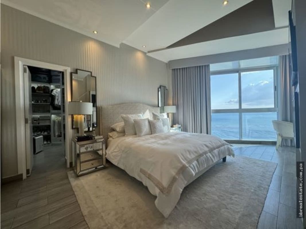 Luxury bedroom with walk-in closet, floor-to-ceiling ocean view windows in Pearl at the Sea Panama
