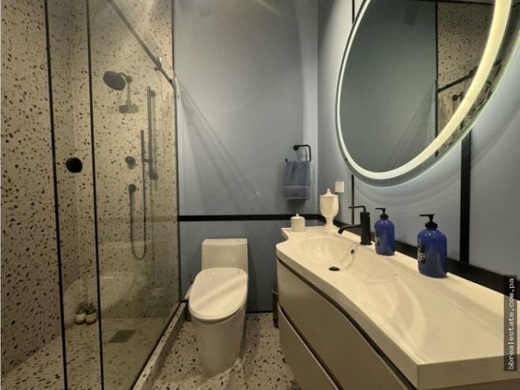 Elegant bathroom featuring terrazzo glass shower, double sinks, illuminated mirror Costa del Este