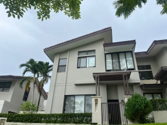 Exterior view of modern house with covered porch, large windows and landscaped garden in PH Nativa Panama Pacifico