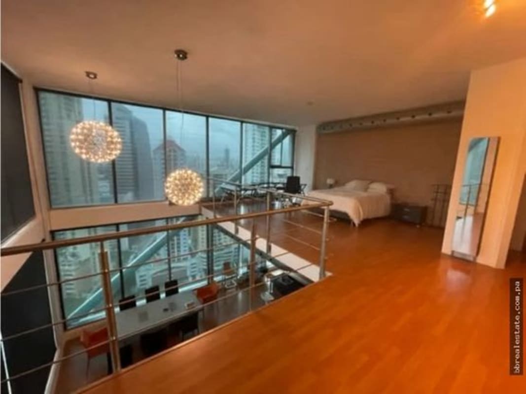 Mezzanine bedroom overlooking city skyline with glass railing and large windows PH Loft Four 41 Punta Pacifica Panama