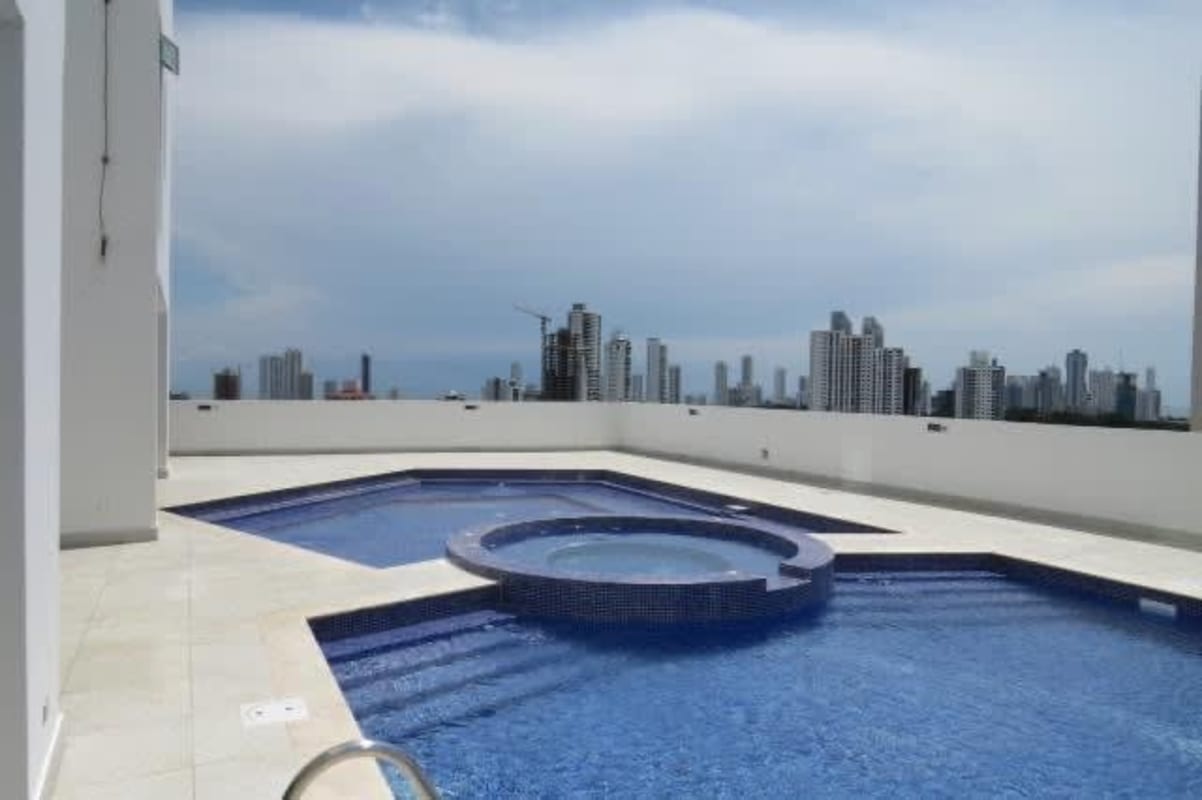 Apartment kitchen with black granite countertops, electric stove, refrigerator in PH Foresta Tower Hato Pintado Panama City