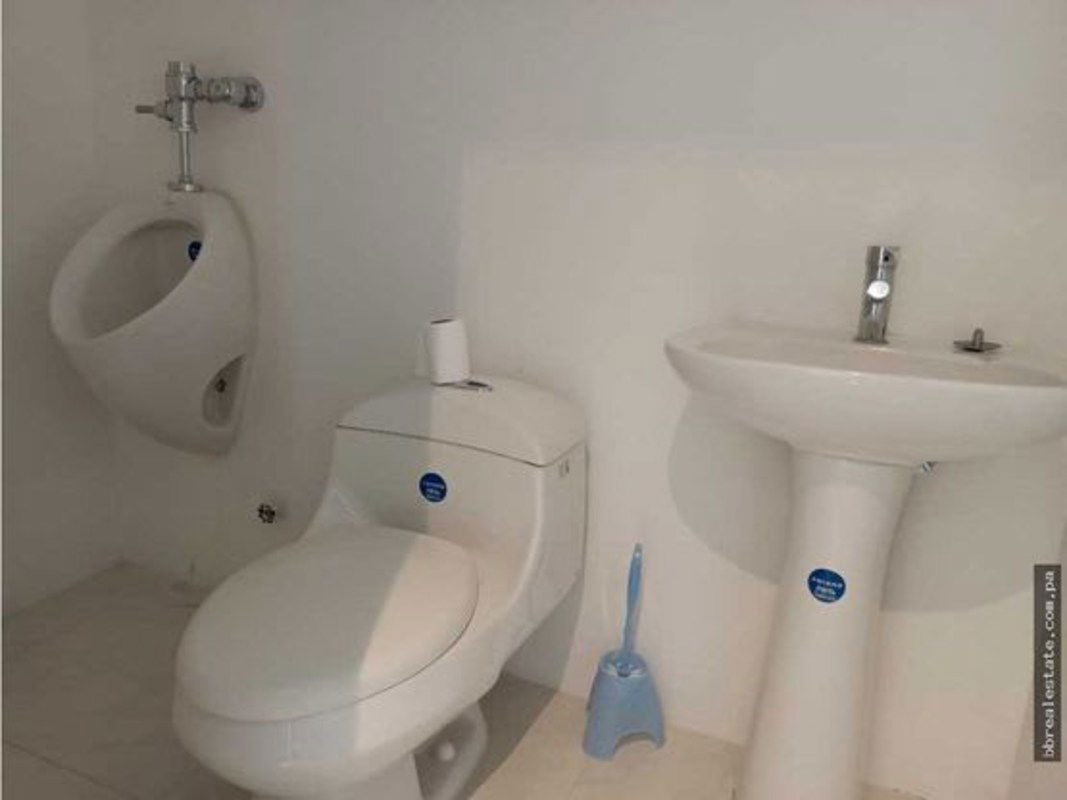 Commercial restroom with pedestal sink, urinal and toilet in Torre Ancón Costa del Este Panama