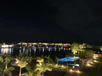 Illuminated waterfront swimming pool with tropical landscaping and reflections at Puntarena Buenaventura Panama