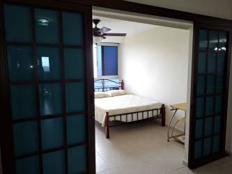 Living room with red sofa large balcony ocean view Coronado Bay beach condo Panama